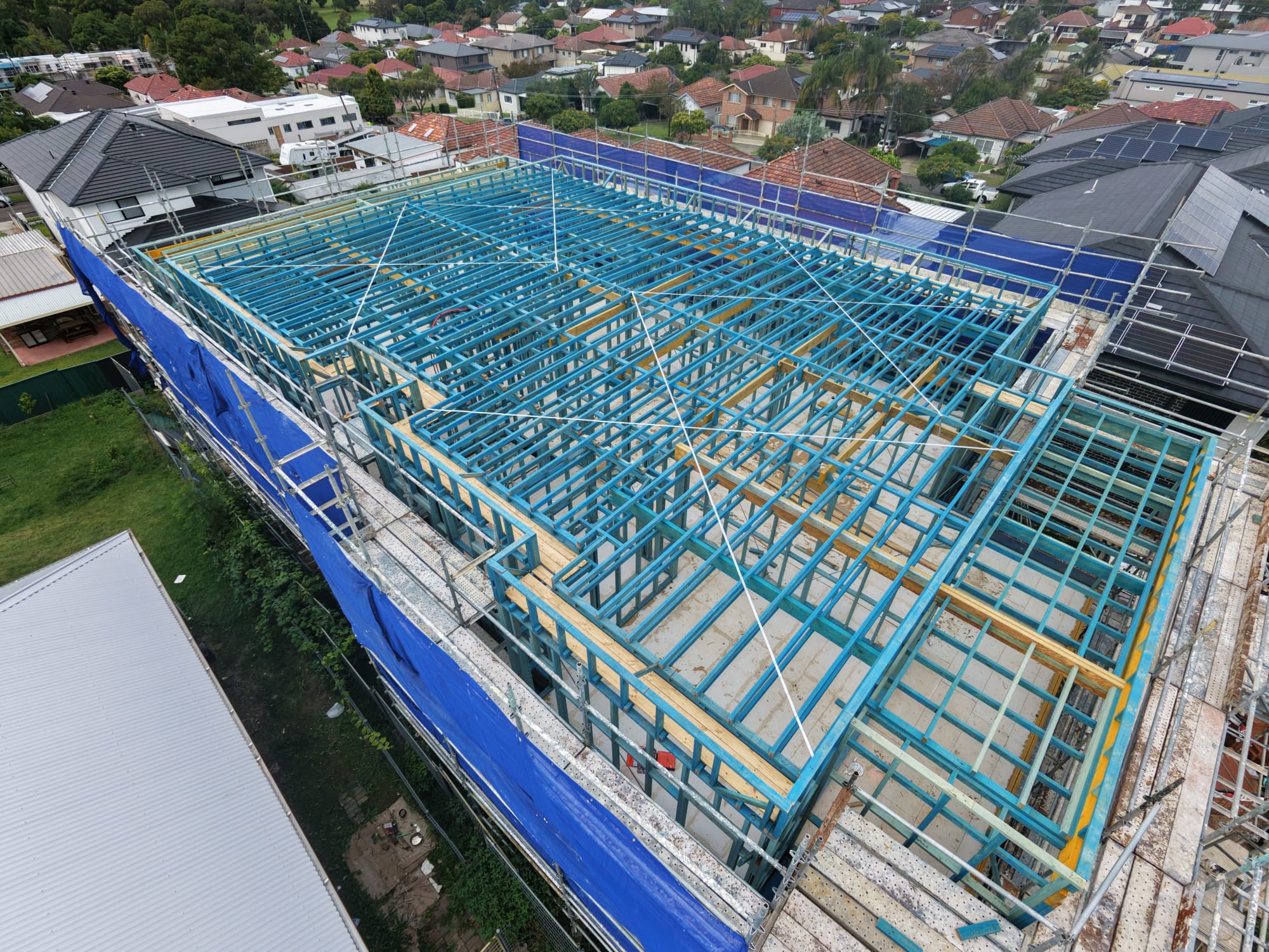Two-storey timber frame with floor joists and scaffolding in place